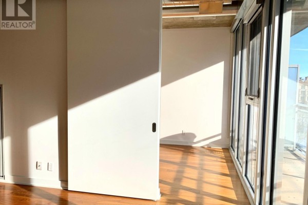 Interior view of an apartment showing a sliding door and large windows with city views. - 704 - 354 Gladstone Avenue, Ottawa