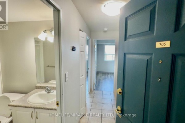 Interior view from front door showing entrance hallway, bathroom, and doorway to bedroom. - 705 - 593 Strasburg Road, Kitchener