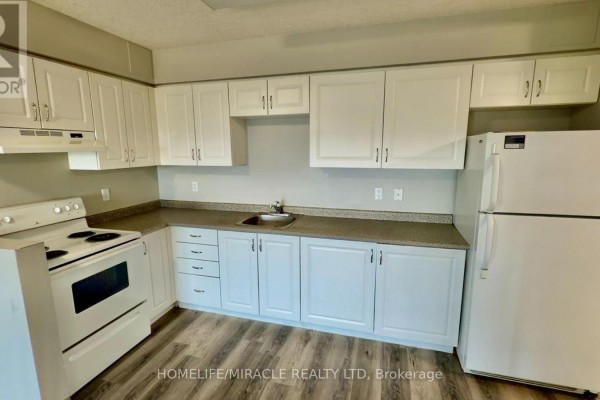L-shaped kitchen with white cabinets, countertops, white stove, and a white refrigerator. - 705 - 593 Strasburg Road, Kitchener
