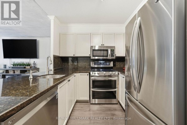 White Murphy bed and built-in storage units with a small desk and window view. - 705 - 600 Queens Quay W, Toronto