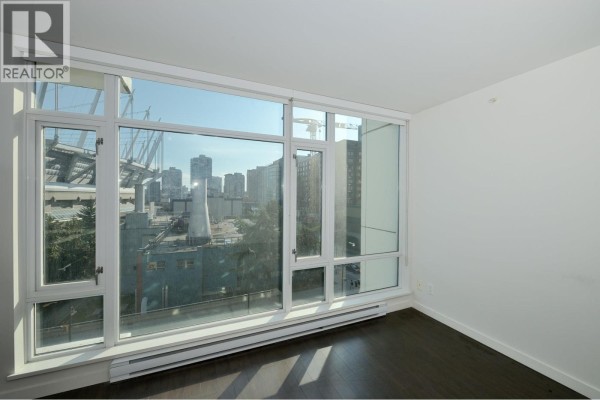 Apartment living area with floor-to-ceiling windows offering panoramic views of the city skyline. - 705 161 W Georgia Street, Vancouver