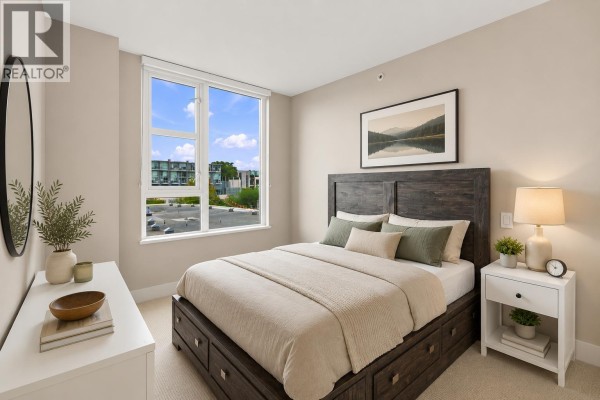 Bedroom with dark wood bed frame, white dresser, and a large window with sky view. - 705 538 W 7th Avenue, Vancouver