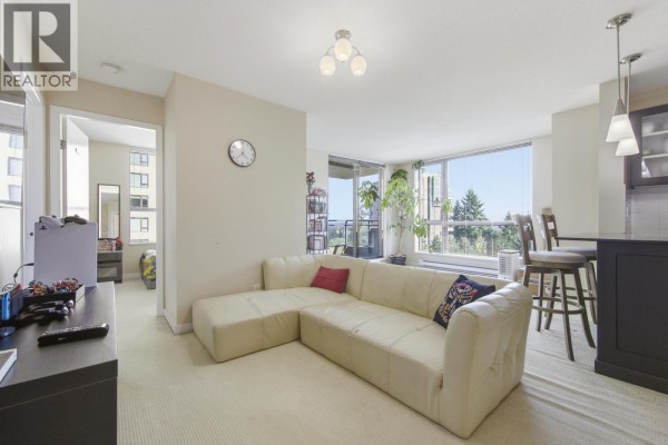 Apartment entryway with a dark wood door, full-length mirror, and tile flooring. - 705 7225 Acorn Avenue, Burnaby