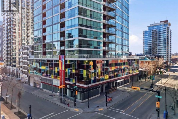 Street-level view of the building entrance with colorful stained glass panels on the lower floors. - 706, 135 13 Avenue Sw, Calgary