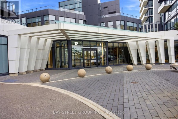 Modern building entrance with white pillars, glass and stone exterior. - 706 - 18 Water Walk Drive, Markham