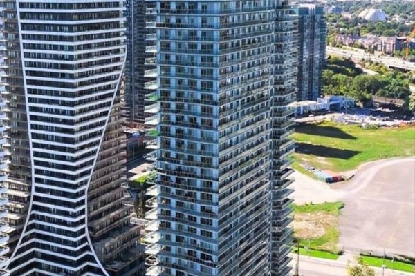Exterior view of two tall glass-facade apartment buildings with balconies. - 706 - 33 Shore Breeze Drive, Toronto