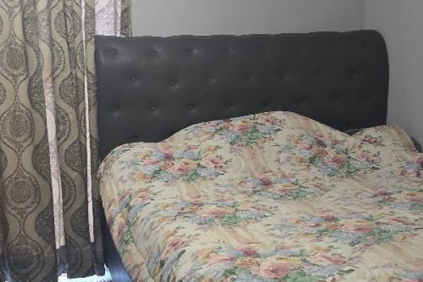 Bedroom featuring a tufted headboard and floral bedding with patterned curtains - 706 - 600 Rexdale Boulevard, Toronto