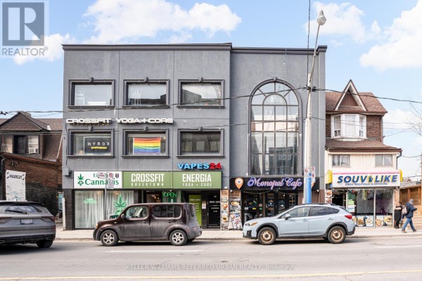 A multi-story commercial building facade with several businesses on the ground floor. - 706 Pape Avenue, Toronto