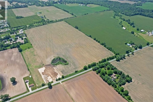 Aerial view of extensive farmland with a pond and cleared construction area on the property. - 707016 Township Road 2 Road, Princeton