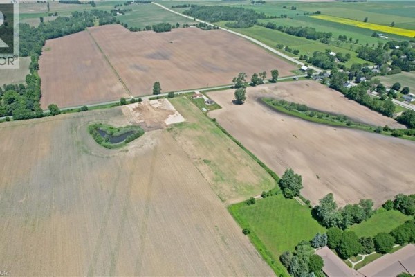Distant aerial view of rural land, fields, a pond, and scattered buildings. - 707016 Township Road 2 Road, Princeton