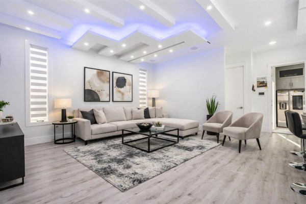 Contemporary living area featuring a fireplace, large TV, and plush seating - 7079 194a Street, Surrey