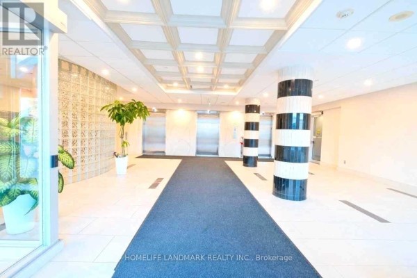 Building lobby with patterned carpet, circular seating, and decorative columns. - 708 - 1470 Midland Avenue, Toronto