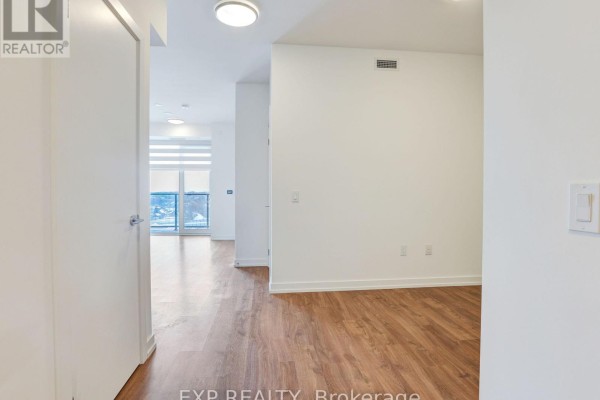 Open living area with hardwood flooring and large windows for natural light - 708 - 15 Wellington Street S, Kitchener