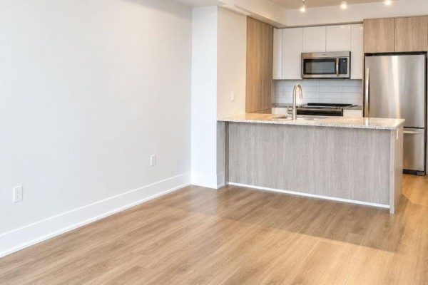 Interior view of the open concept living space and modern kitchen with light wood cabinets. - 708 - 9 Valhalla Inn Road, Toronto