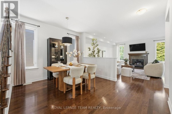 Open concept dining room and living room with hardwood floors and large windows. - 708 Eagle Crest Heights, Ottawa