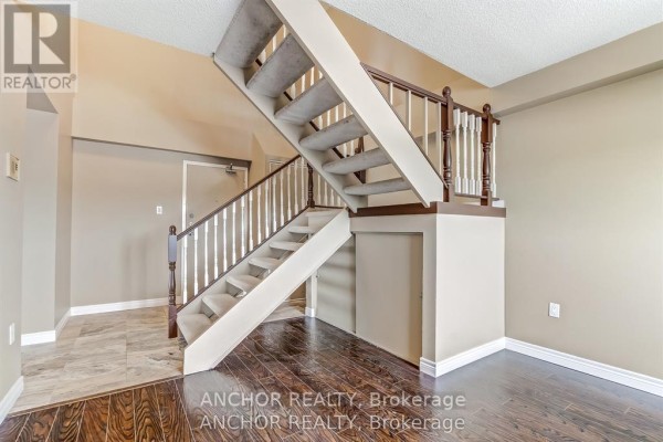 Staircase with carpeted steps and wooden banister in a hallway. - 709 - 1255 Commissioners Road W, London South
