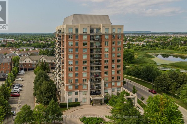Front view of a multi-story brick apartment building with balconies and many windows. - 709 - 2325 Central Park Drive, Oakville