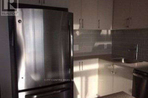 Stainless steel refrigerator in a modern kitchen with white cabinets. - 709 - 2560 Eglinton Avenue W, Mississauga