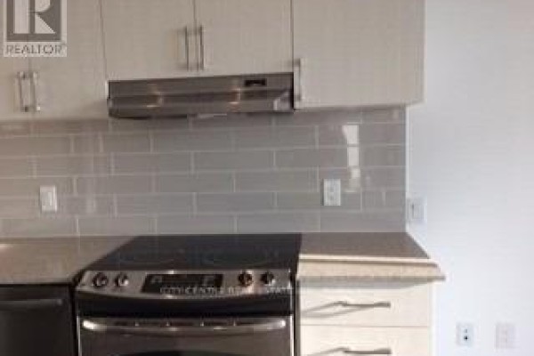 Electric stove and grey subway tile backsplash in a modern kitchen. - 709 - 2560 Eglinton Avenue W, Mississauga