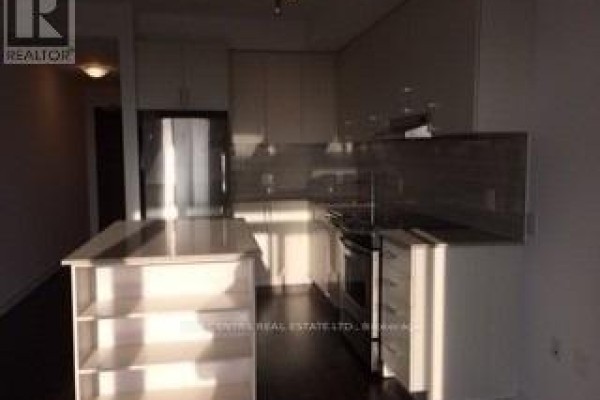 Kitchenette with stainless steel appliances, white cabinetry, and island. - 709 - 2560 Eglinton Avenue W, Mississauga