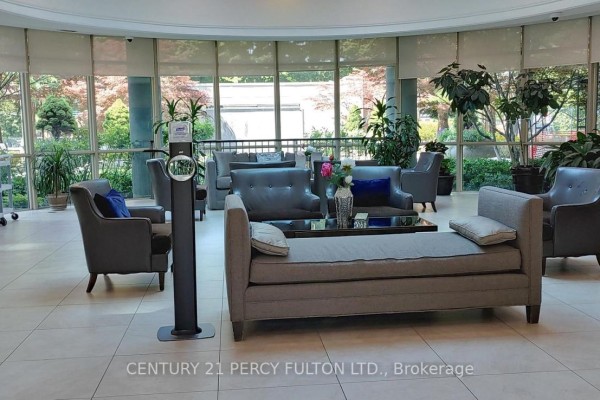 Lobby seating area with grey sofas, chairs, and large windows. - 709 - 28 Harrison Garden Boulevard, Toronto