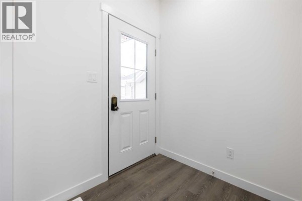 Entryway with a white door and window, featuring light wood flooring - 709 Clearview Green, Chestermere