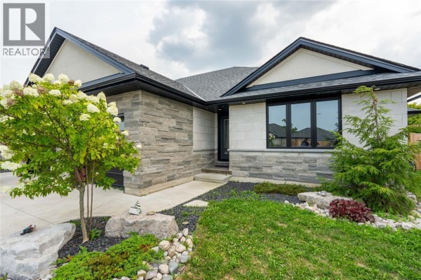 Close-up of the house entrance with stone cladding and a small tree. - 709 Ferdinands Crescent, Sarnia