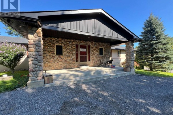 Front entrance with stone columns, covered porch, and red door. - 709 Roland Road, Pelham