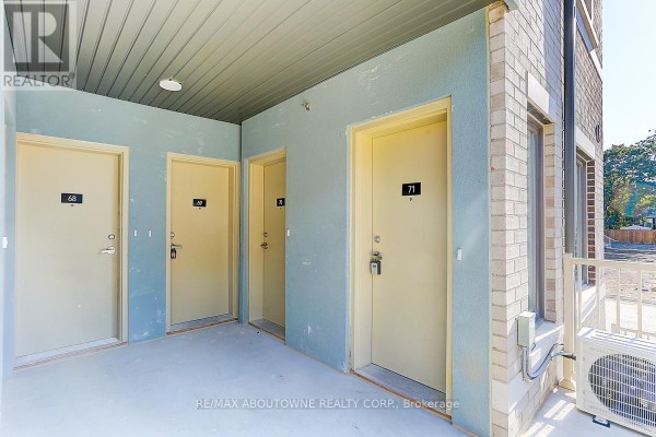 Covered walkway with four doors, including unit 71, and an outdoor air conditioning unit. - 71 - 5 William Jackson Way, Toronto