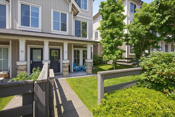 Wooden bridge crossing a small stream in a landscaped garden with lush green bushes and trees. - 71 31032 Westridge Place, Abbotsford