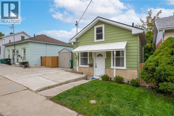 Side view of the green house exterior showing driveway and lawn. - 71 Beverly Street, Cambridge