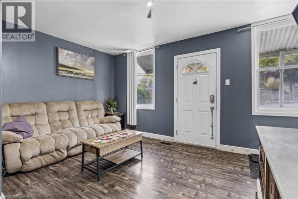 Living room with a beige sofa, coffee table, and dark blue walls. - 71 Beverly Street, Cambridge