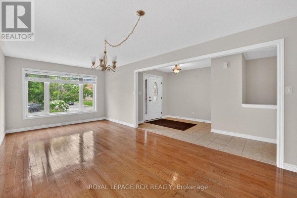 Living room and foyer with hardwood floors, gray walls, and tiled entrance. - 71 Elmwood Avenue, Brock