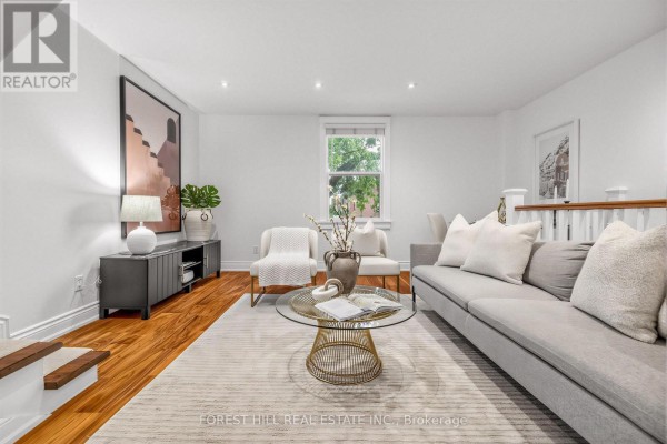Living room with a grey sofa, coffee table, and two armchairs. - 71 Emerson Avenue, Toronto