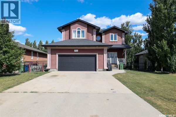 Front view of the red brick house with a paved driveway and surrounding greenery. - 71 Fairway Crescent, White City