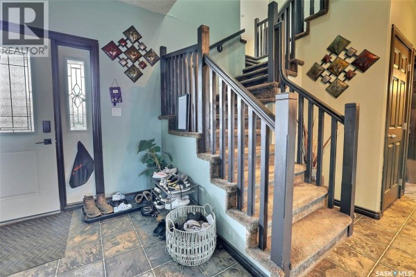 Interior staircase with carpeted steps, dark wood railing, and teal walls. - 71 Fairway Crescent, White City