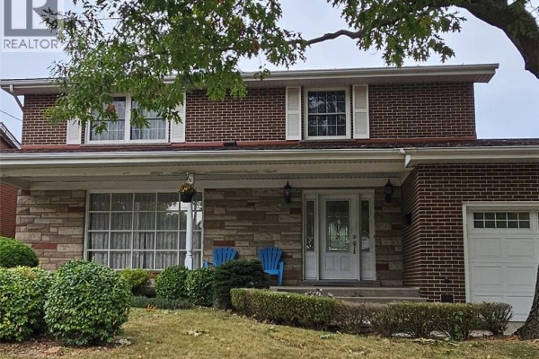 Close-up of the front entrance featuring a white door, stone pillars, and two blue Adirondack chairs. - 71 Margate Avenue, Hamilton
