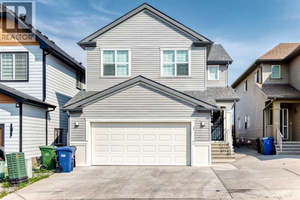 Front exterior of a grey vinyl-sided two-storey house with a double garage. - 71 Martha's Meadow Close Ne, Calgary