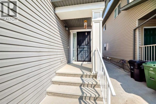 Steps leading up to the front entrance of a grey vinyl-sided house. - 71 Martha's Meadow Close Ne, Calgary