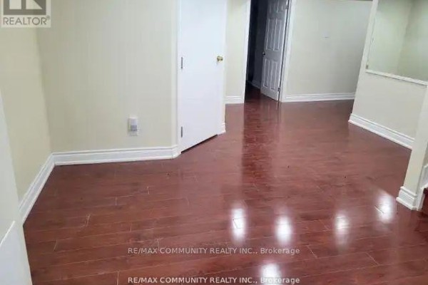 Unfurnished room with cream walls, white baseboards, and dark laminate flooring. - 71 Middlecote Drive, Ajax