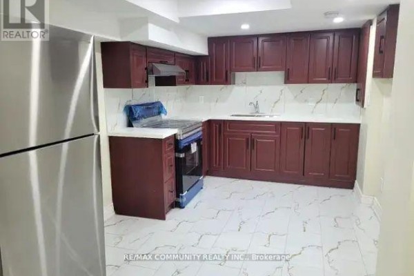 Kitchen with dark wood cabinets, white marble-patterned tile flooring, and stainless steel refrigerator. - 71 Middlecote Drive, Ajax