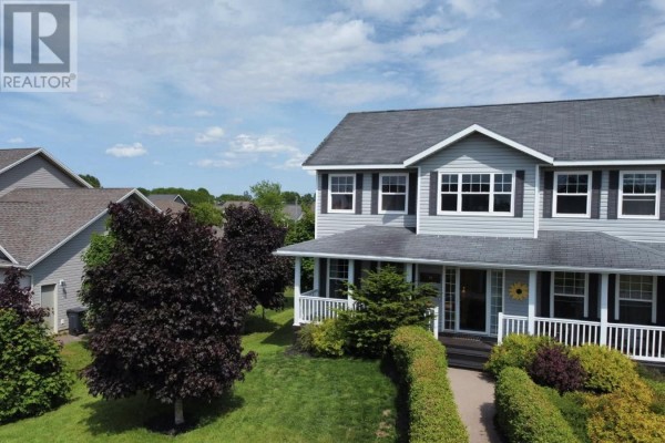 Aerial view of a two-story grey house with a covered front porch and manicured landscaping. - 71 Rebecca Drive, Summerside