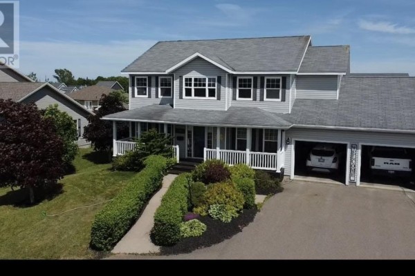 Front exterior of a two-story grey house with a double garage and paved driveway. - 71 Rebecca Drive, Summerside