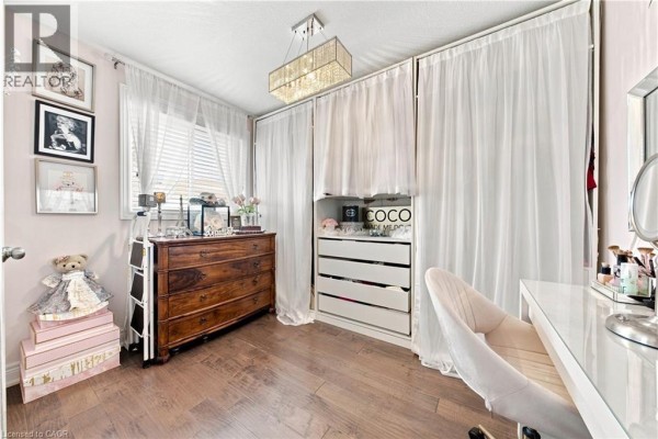 Vanity, dresser, and white drawers in a room with wood floors and sheer curtains - 71 Riviera Ridge Stoney Creek