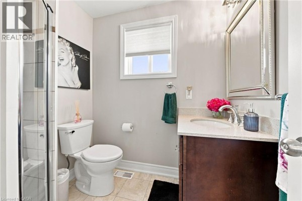 Bathroom with glass shower, toilet, vanity, and Marilyn Monroe art - 71 Riviera Ridge Stoney Creek
