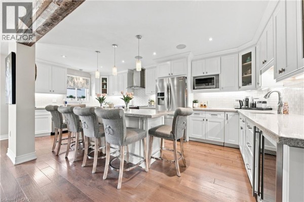 Modern kitchen with island, stainless steel appliances, and white cabinets - 71 Riviera Ridge Stoney Creek