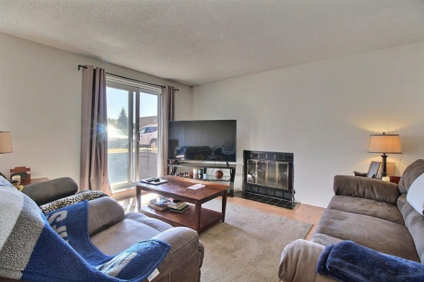 Living room with two sofas, a coffee table, television, and a fireplace. - 71 Rue De Sauternes, #1, Gatineau