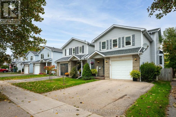 Row of grey houses with attached garages and manicured front lawns on a residential street. - 71 Shirley Street, Orangeville