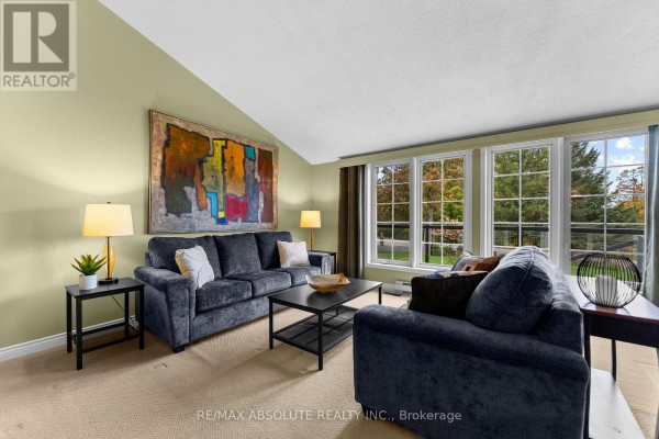 Living room with beige carpet, light green walls, a large abstract painting, and large windows. - 71 Toner Road, Mcnab/braeside