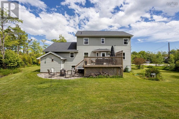 Back view of a grey house with a wooden deck and patio. - 71 Yezen Court, Hammonds Plains
